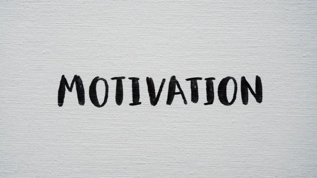 Inspirational word 'Motivation' in black on a white textured canvas background.